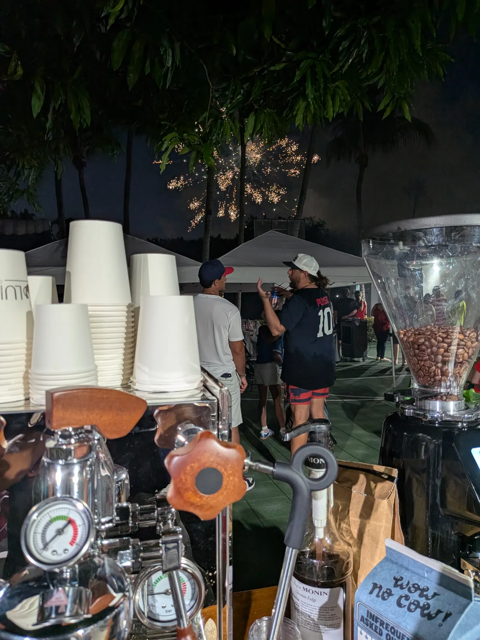Luisa Coffee cart serving guests at a festive evening celebration with fireworks overhead