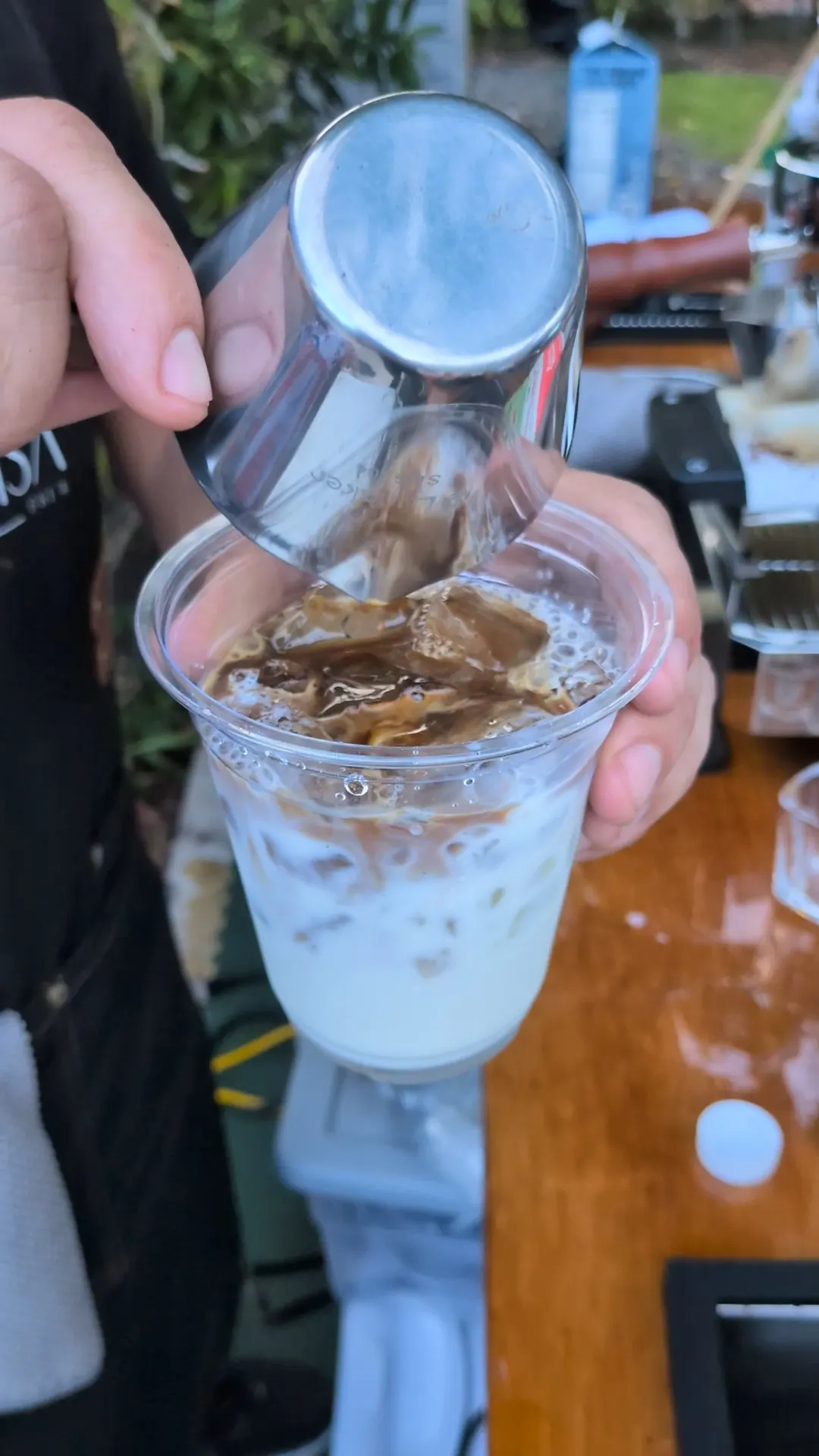 Barista pouring a fresh iced coffee for a guest at a private outdoor event