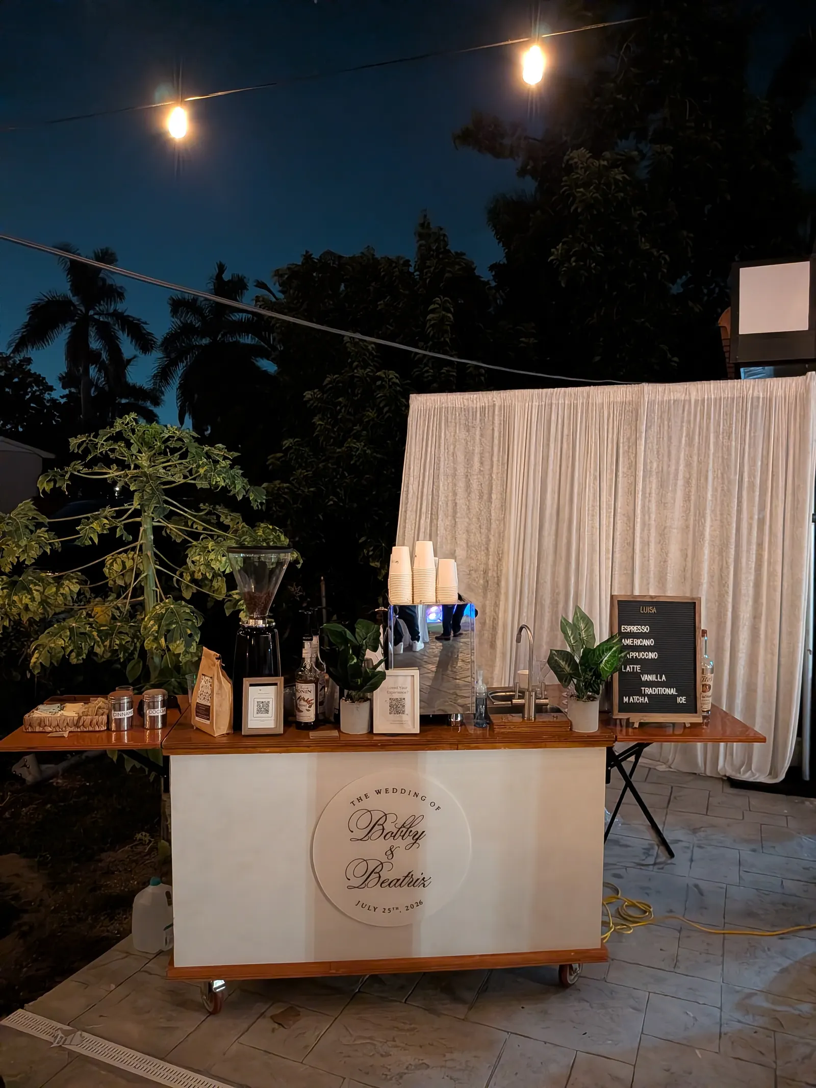 Luisa Coffee cart serving guests at an elegant evening wedding reception under string lights